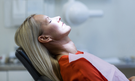 Patient relaxing while laid back in dental chair